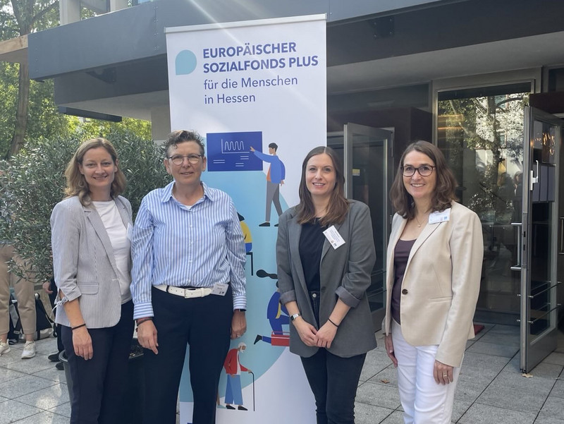 Larissa Gleede (HMWVW), Renate-Anny Böning (involas), Nora Brand (involas), Ingrid Weinreich (FRESKO e.V.). stehen wir dem Tagungsort vor einm Roll-Up des ESF